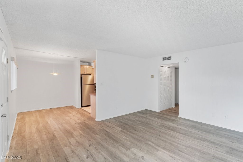 350 East Desert Inn Road, Unit H205 Las Vegas, NV 89109 - Photo 6 of 30 Unfurnished room featuring light wood-style floors and a textured ceiling