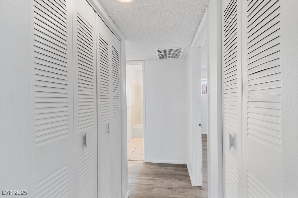 350 East Desert Inn Road, Unit H205 Las Vegas, NV 89109 - Photo 9 of 30 Hall with wood finished floors and a textured ceiling