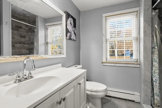 a bathroom with a sink a toilet and a window