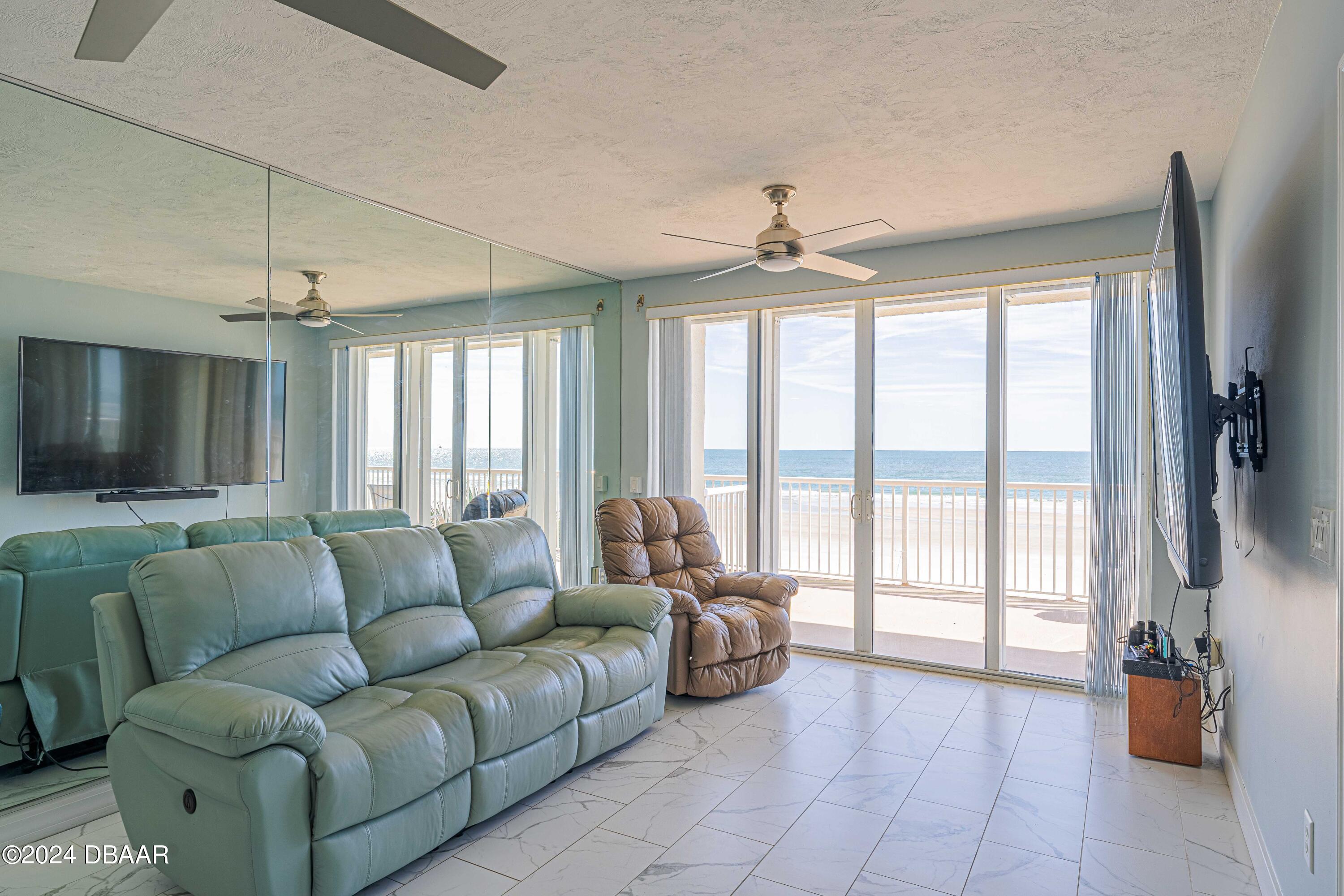4767 South Atlantic Avenue, Unit 204 Ponce Inlet, FL 32127 - Photo 7 of 26 a living room with furniture and a flat screen tv