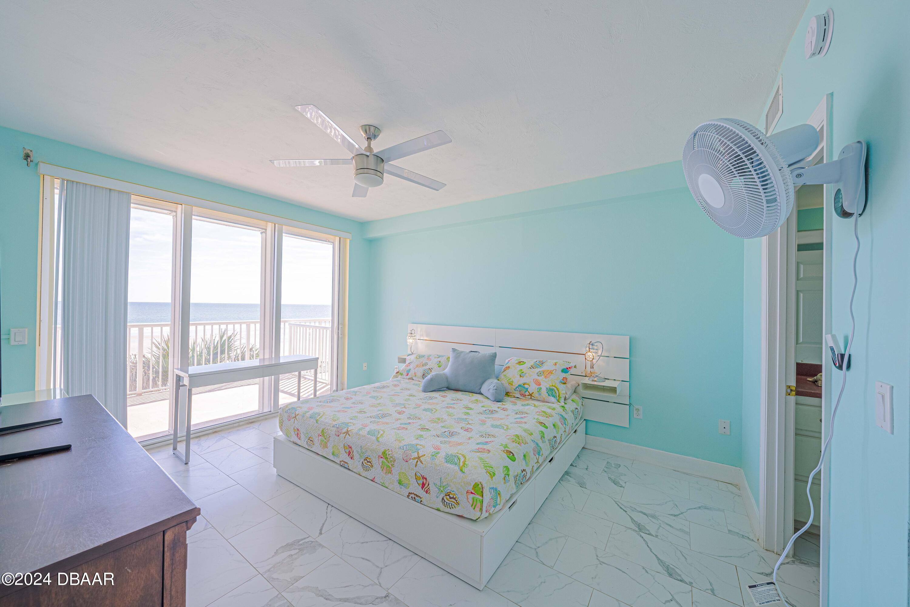 4767 South Atlantic Avenue, Unit 204 Ponce Inlet, FL 32127 - Photo 10 of 26 a bedroom with a large bed and a chandelier