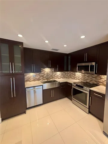 a kitchen with stainless steel appliances granite countertop a sink counter space and cabinets