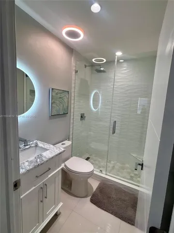 a bathroom with a granite countertop sink toilet and shower