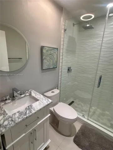 a bathroom with a granite countertop sink toilet and shower