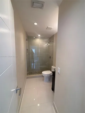 a bathroom with a granite countertop sink a toilet and shower