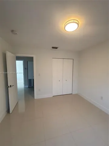 an empty room with closet and mirror