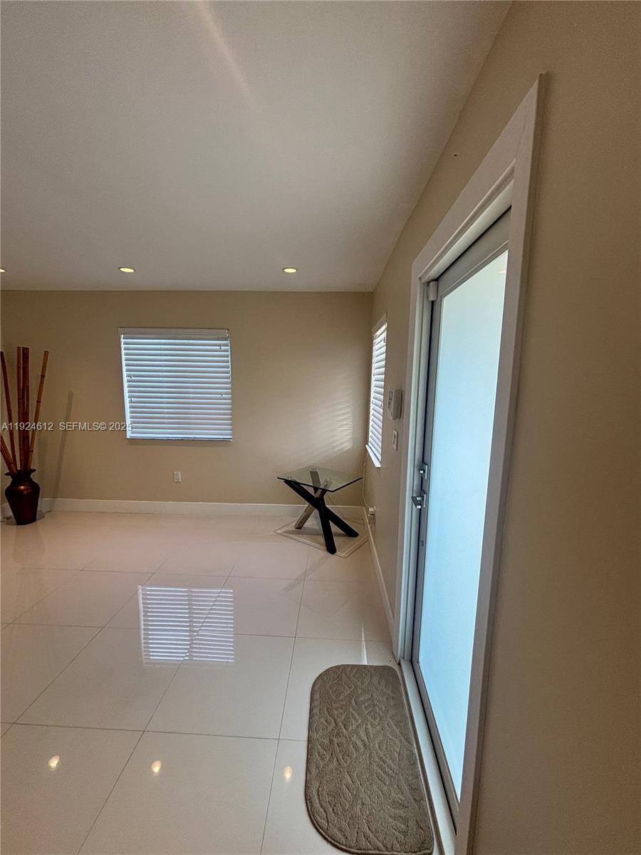 13765 Southwest 160th Terrace Miami, FL 33177 - Photo 5 of 47 a hallway with a couch and a potted plant next to a window