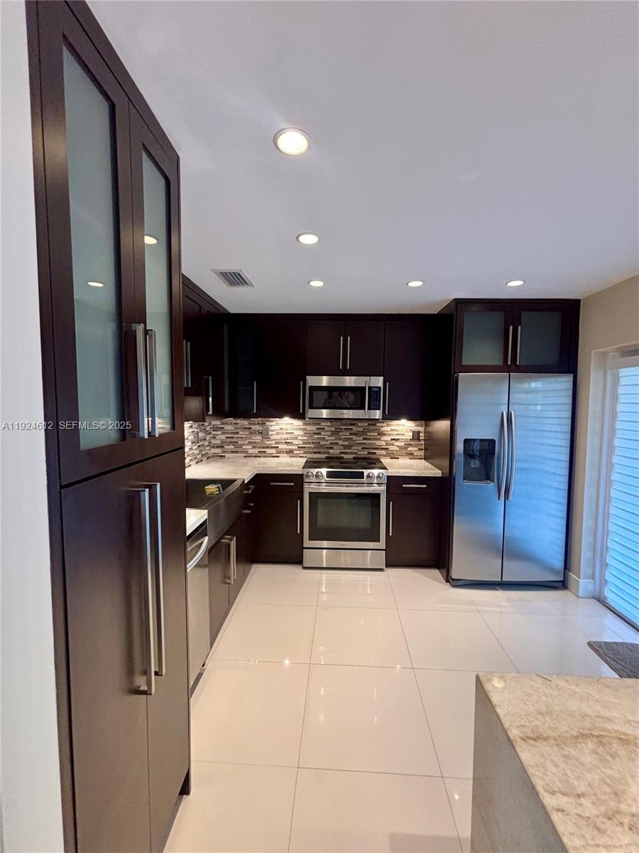 13765 Southwest 160th Terrace Miami, FL 33177 - Photo 9 of 47 a kitchen with stainless steel appliances kitchen island granite countertop a stove a sink and a refrigerator