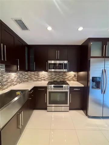 a kitchen with stainless steel appliances granite countertop a sink and stove top oven