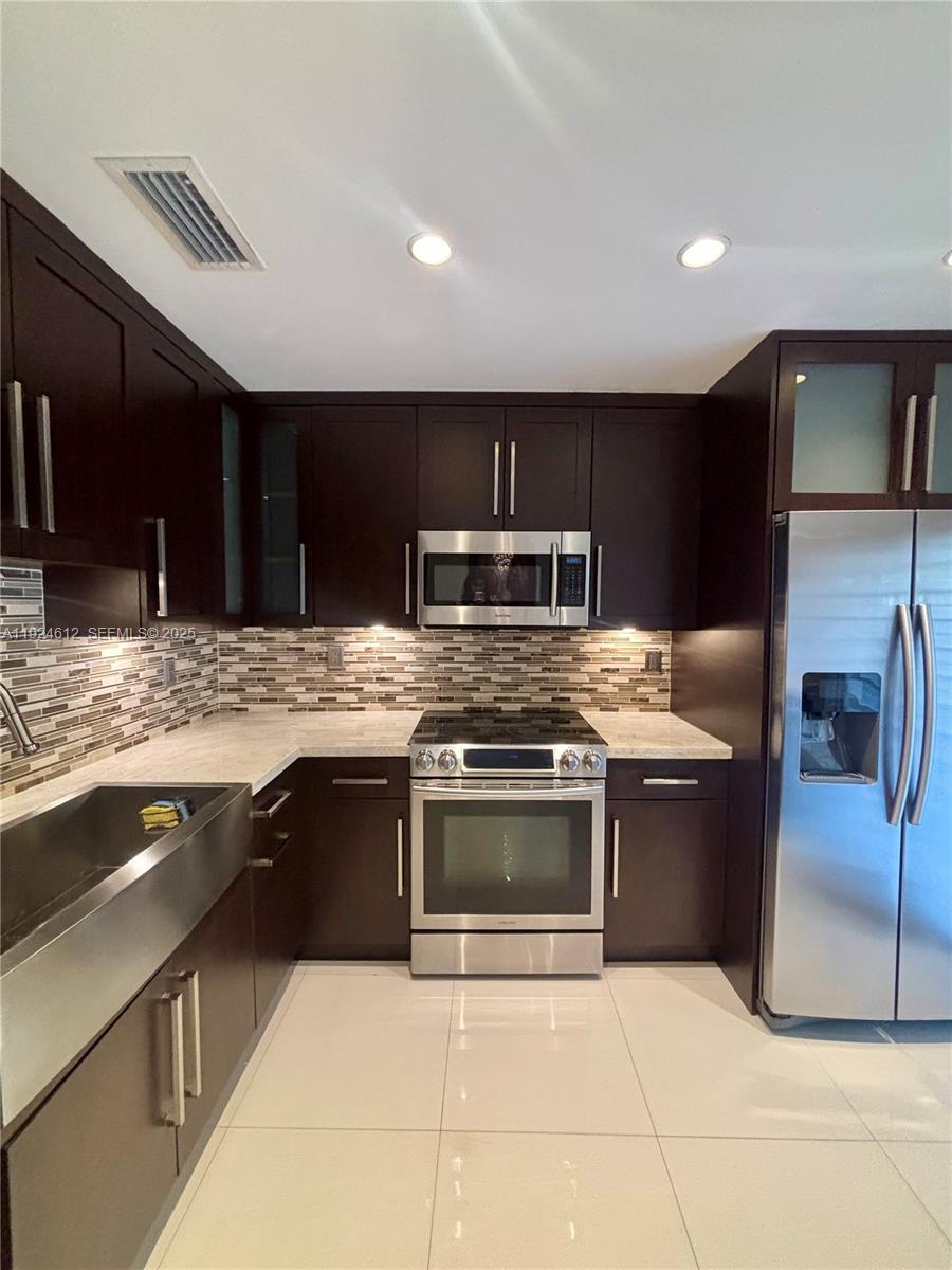 13765 Southwest 160th Terrace Miami, FL 33177 - Photo 10 of 47 a kitchen with stainless steel appliances granite countertop a sink and stove top oven
