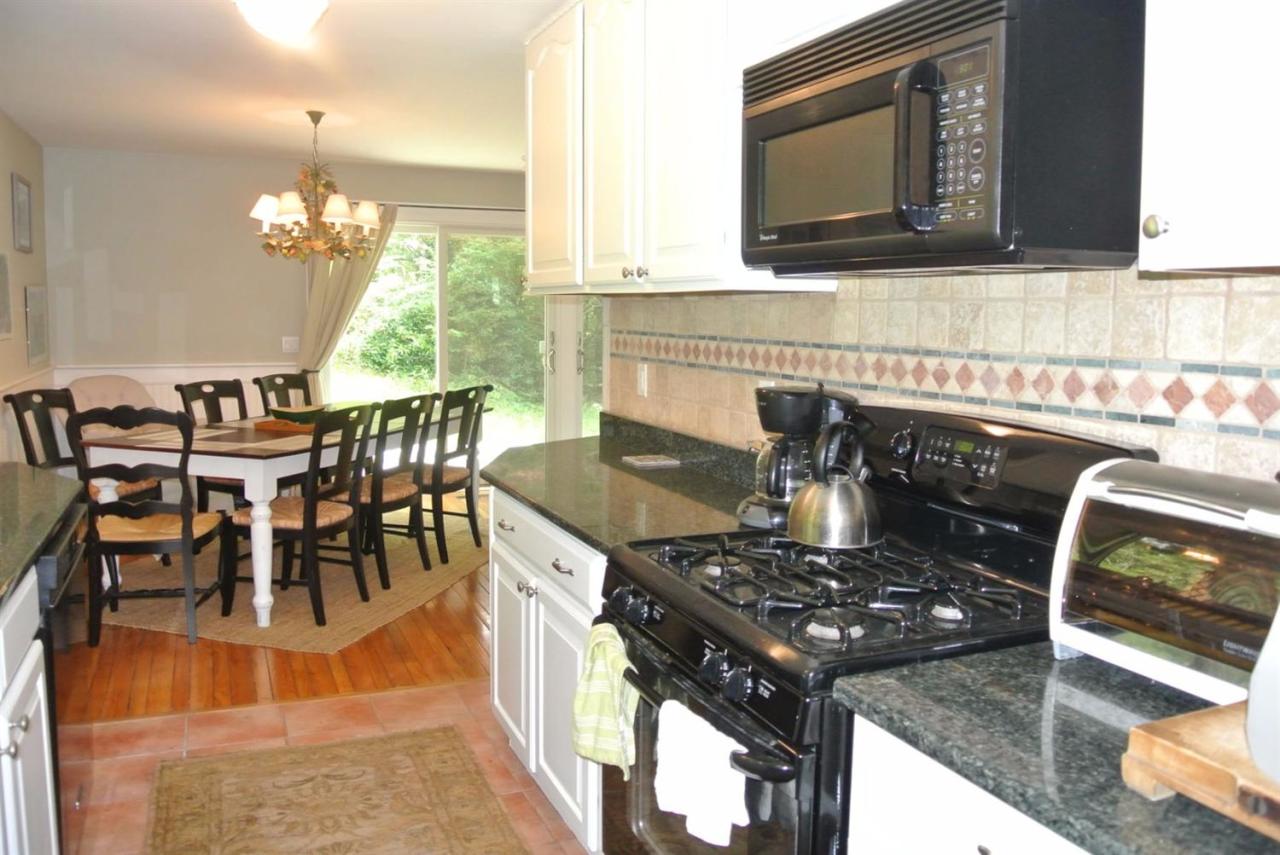 83 Summersea Road Mashpee, MA 02649 - Photo 5 of 25 a kitchen with a stove a sink a dining table and chairs