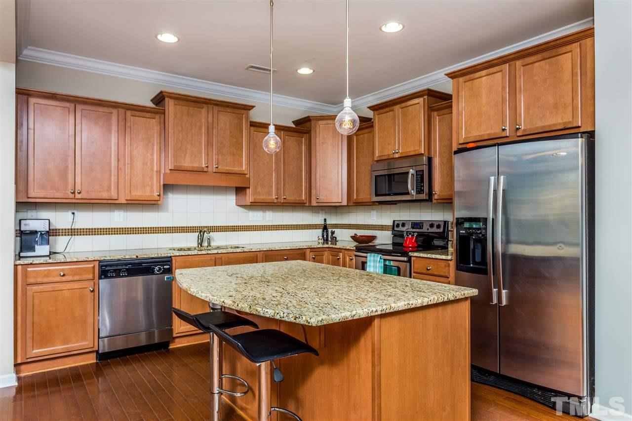 2410 Memory Ridge Drive Raleigh, NC 27606 - Photo 2 of 20 a kitchen with granite countertop a refrigerator a sink a stove a microwave and wooden floor