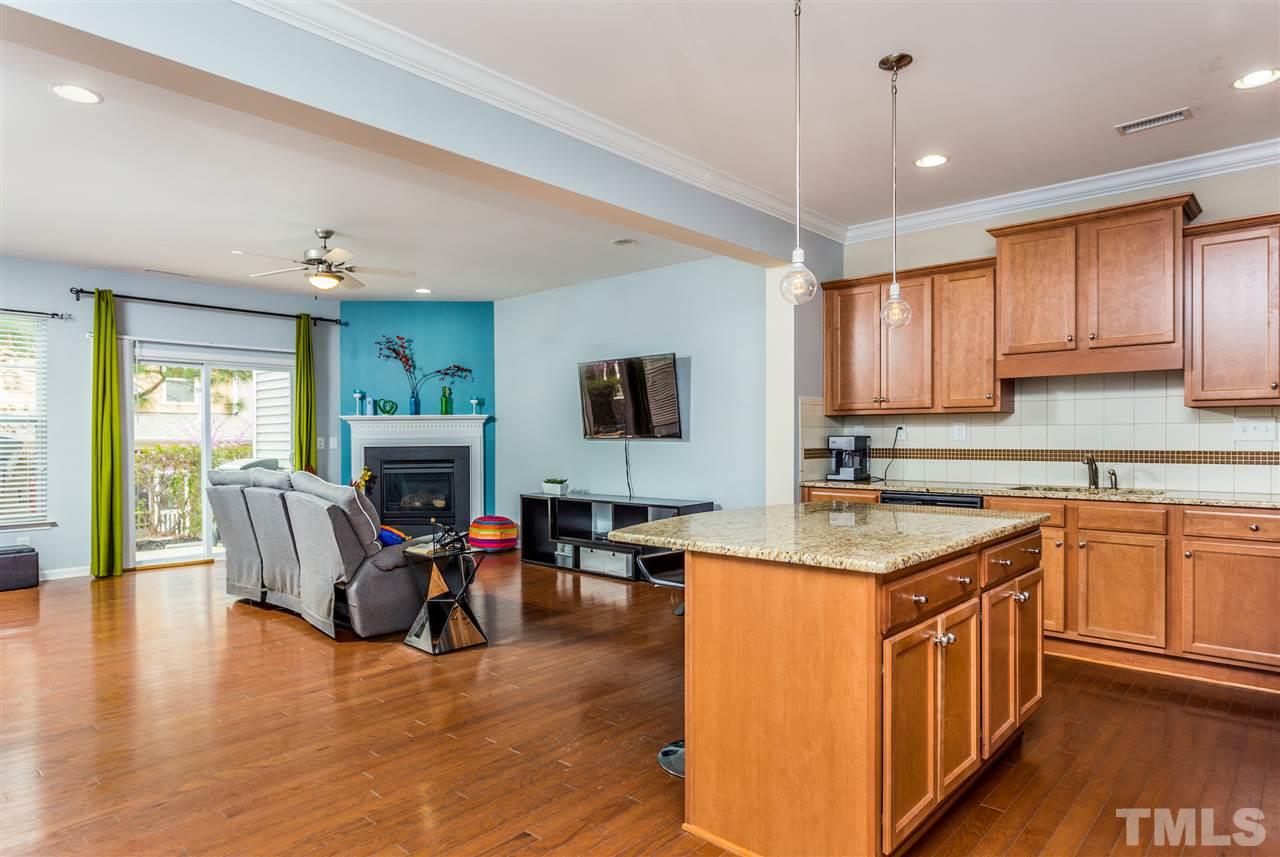 2410 Memory Ridge Drive Raleigh, NC 27606 - Photo 4 of 20 a kitchen with stainless steel appliances granite countertop a stove top oven a sink dishwasher a dining table and chairs with wooden floor
