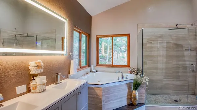 a bathroom with a granite countertop sink and a bathtub