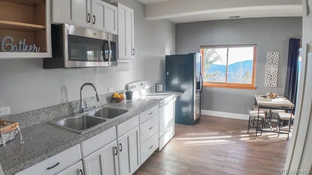 a kitchen with stainless steel appliances granite countertop a sink a stove and a refrigerator