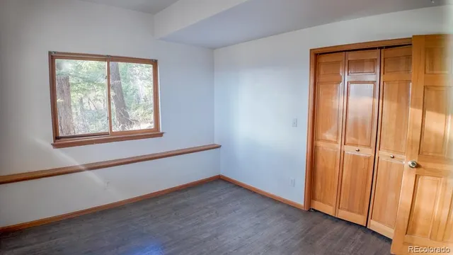 an empty room with wooden floor and a window