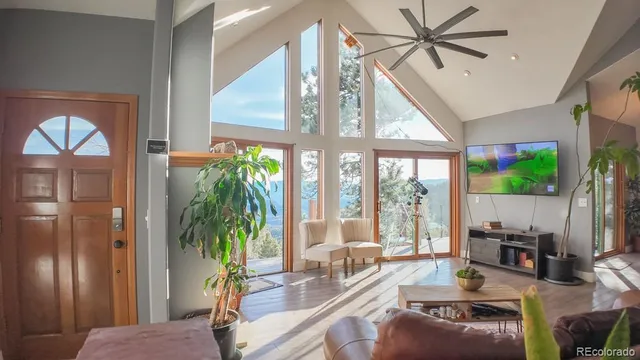 a living room with furniture a floor to ceiling window and a flat screen tv
