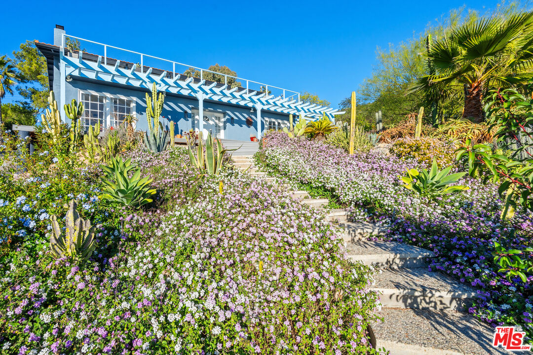 9402 Houston Road Malibu, CA 90265 - Photo 4 of 30 a view of building with garden space and plants