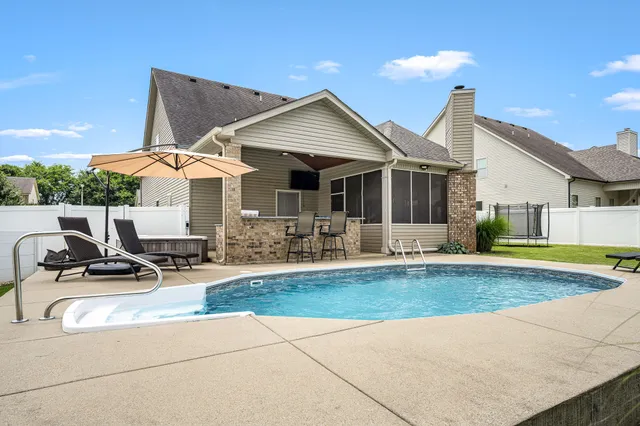 a view of a house with backyard and sitting area