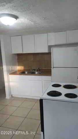 a kitchen with a sink a stove and cabinets