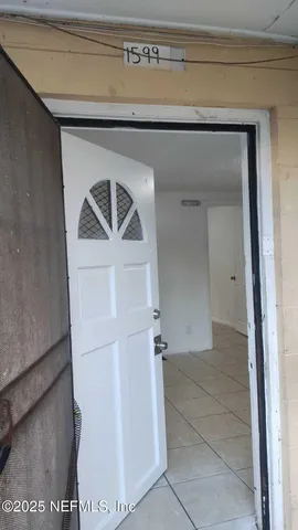 a view of a livingroom with a white wall and a refrigerator
