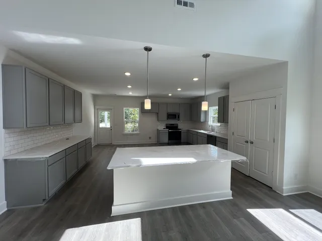 a large white kitchen with a large island oven