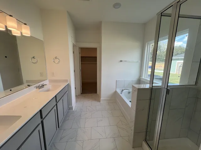 a bathroom with a bathtub sink and mirror