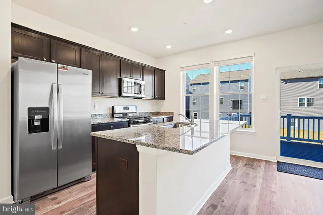 a kitchen with stainless steel appliances granite countertop a refrigerator and a sink