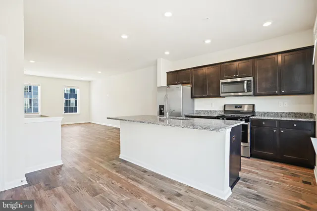 a kitchen with stainless steel appliances granite countertop a stove a sink and a refrigerator