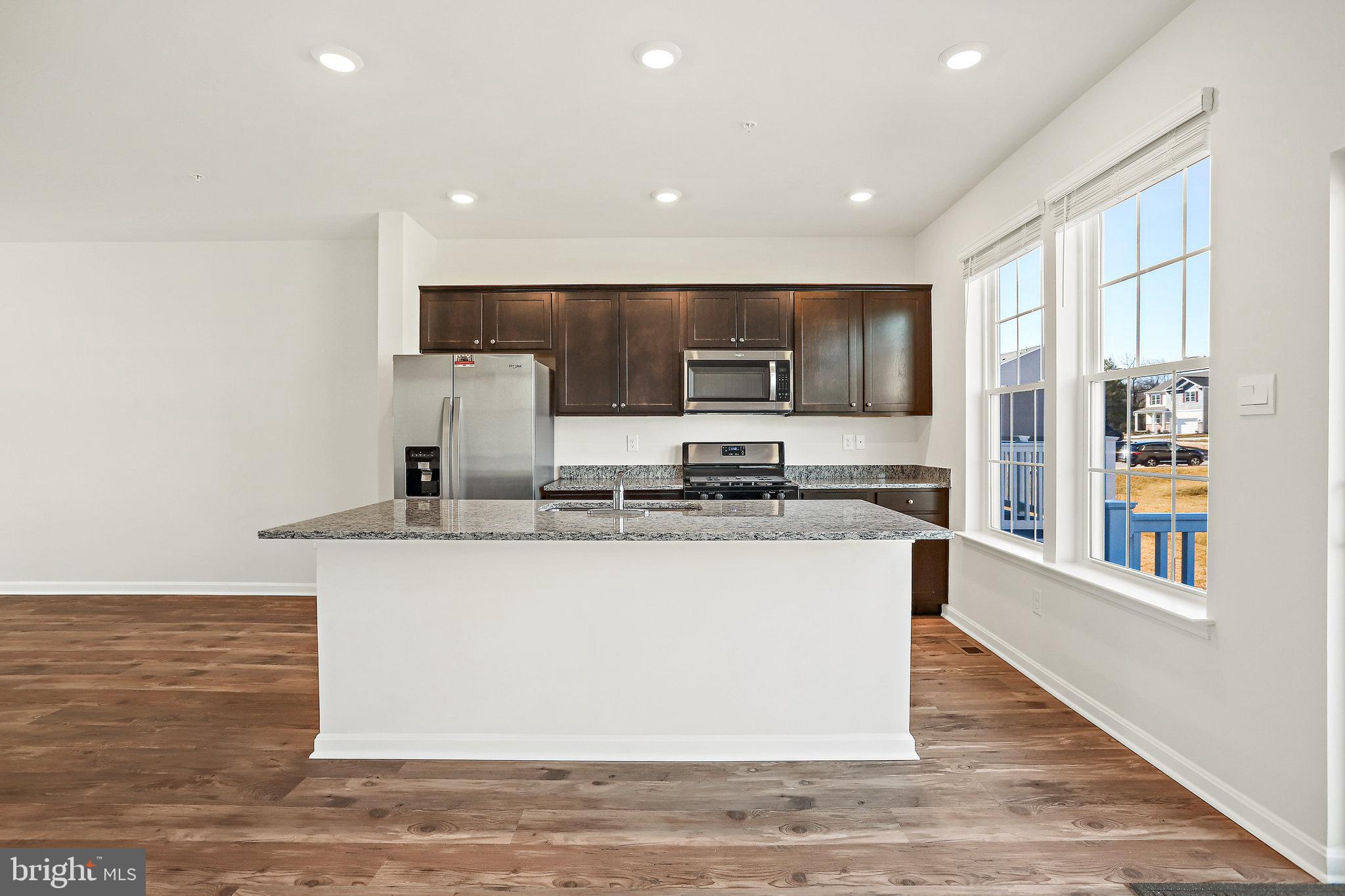 1271 Apollo Drive Frederick, MD 21702 - Photo 14 of 42 a large kitchen with granite countertop a large counter top stainless steel appliances and cabinets