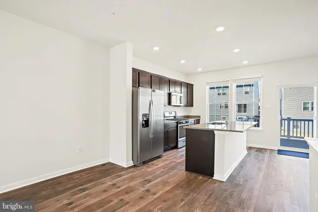 a kitchen with stainless steel appliances a refrigerator and wooden floor
