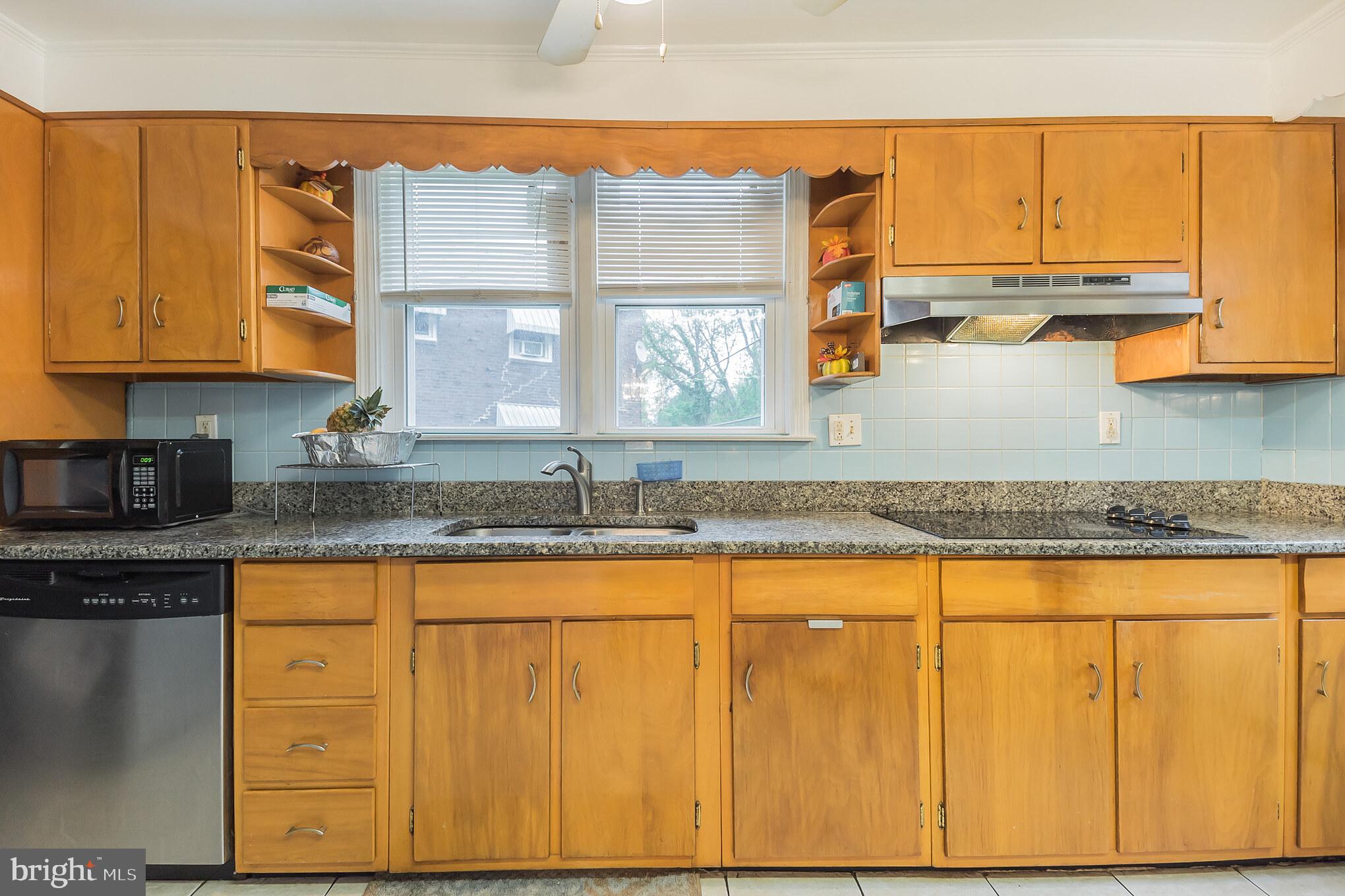 1024 South Lynbrook Road Darby, PA 19023 - Photo 12 of 29 a kitchen with granite countertop wooden cabinets a sink and a window