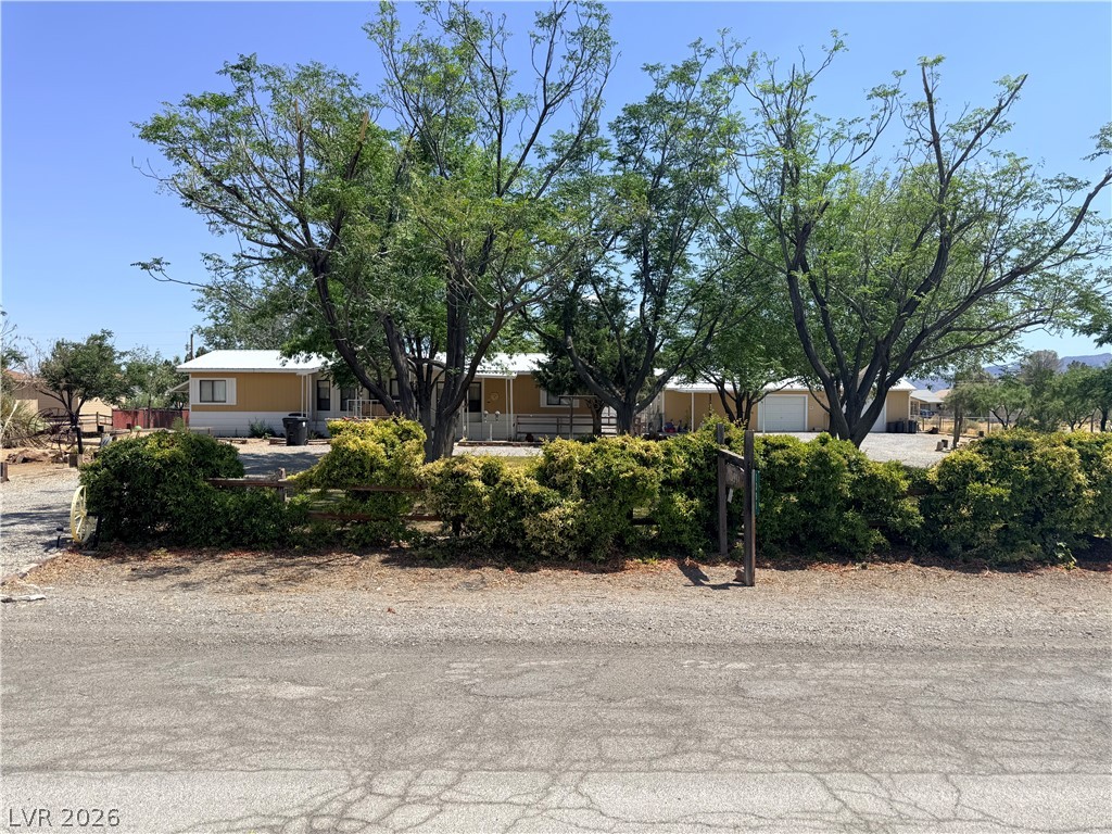 1391 West Dyer Road Pahrump, NV 89048 - Photo 1 of 50 Mature trees and lush hedging enhance the inviting curb appeal of this property.