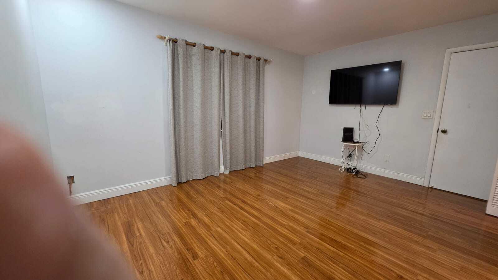 100 Ashbury Road, Unit 206 Hollywood, FL 33024 - Photo 14 of 23 a view of a livingroom with wooden floor and a flat screen tv