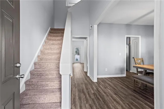 a view of a hallway with wooden floor and staircase