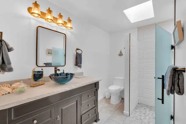 a bathroom with a double vanity sink toilet and mirror