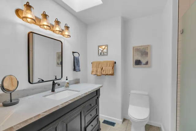 a bathroom with a toilet a sink and mirror