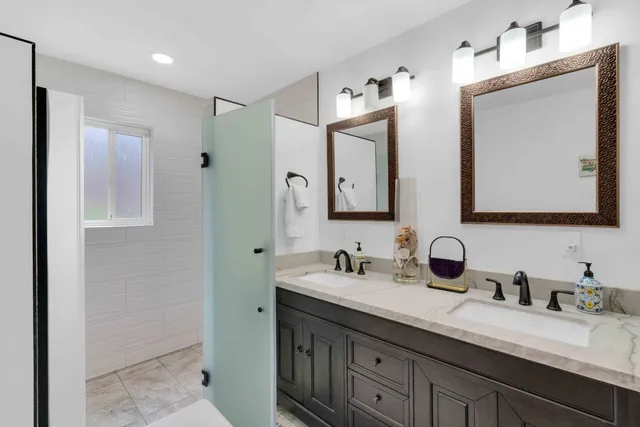 a bathroom with double vanity sinks and a mirror