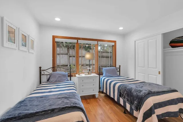 a bedroom with two beds and a large window