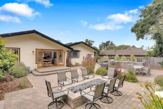 a view of a house with backyard and sitting area