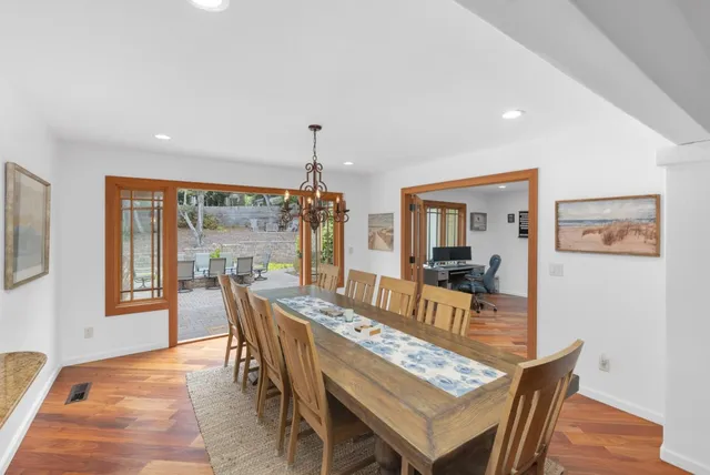 a dining room with furniture a chandelier and wooden floor