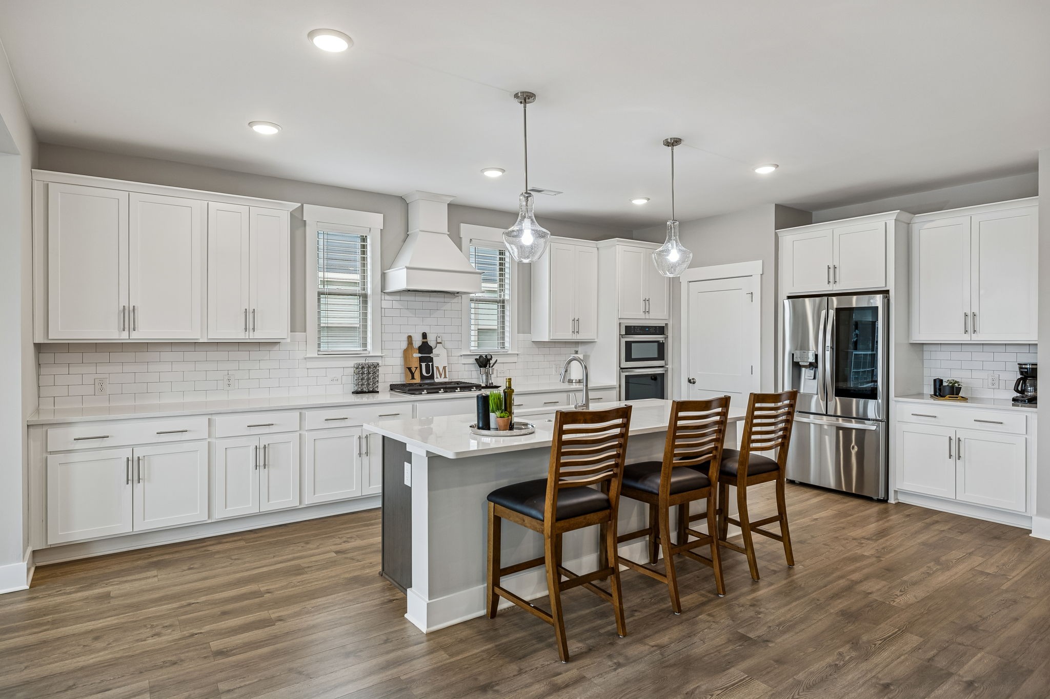 a kitchen with stainless steel appliances kitchen island granite countertop a wooden table chairs and white cabinets