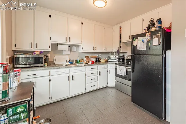 a kitchen with white cabinets and white appliances