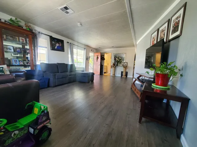 a living room with furniture wooden floor and a flat screen tv