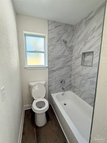 a bathroom with a toilet and a tub