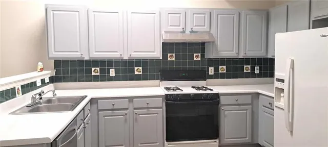 a kitchen with a refrigerator sink and cabinets