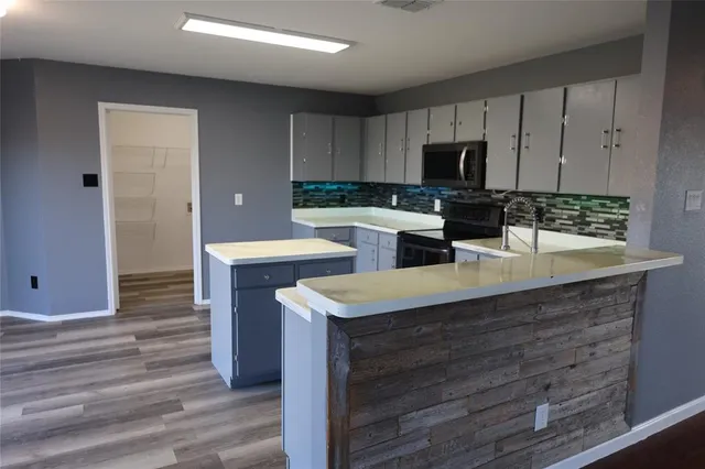 a kitchen with a sink cabinets and wooden floor