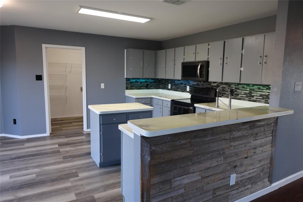 1714 Elm Street Anna, TX 75409 - Photo 2 of 27 a kitchen with a sink cabinets and wooden floor