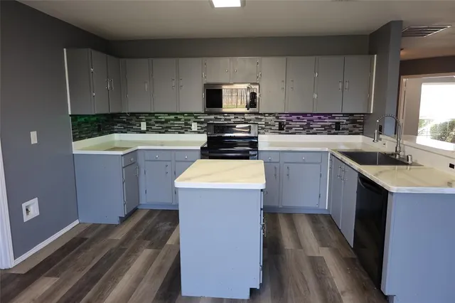 a kitchen with a sink stove and cabinets