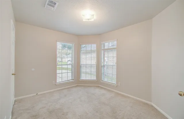 an empty room with windows and closet
